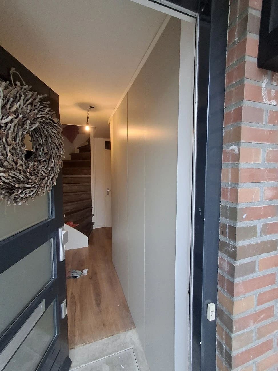 Afgewerkte hal met de meterkast weggewerkt achter een PAX-kastombouw